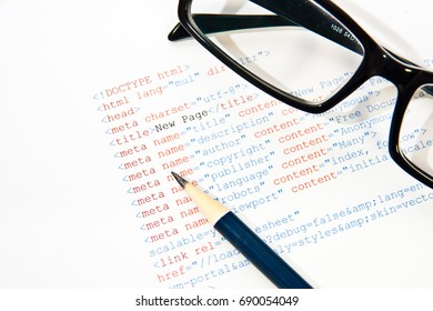 HTML code on paper with pencil and glasses