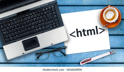 HTML Hyper Text Markup Language. Paper width html tag and laptop, glasses and coffee on wooden table
				