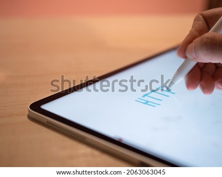HTTP, HyperText Transfer Protocol Hypertext transfer Protocol. The hand makes an inscription on the tablet screen using a stylus, close-up small depth of field