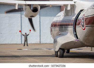 Hua Hin,Thailand- October 31,2017:aircraft marshaller signal to pilot of casa CN-235-220M Royal Thai Police taxi to parking area.CN-235 is a medium range twin engines developed by Spain and Indonesia.