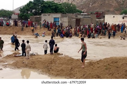 HUB, PAKISTAN - JUL 18: Commuters pass through the stagnant flood water on the road after heavy downpour of monsoon season at Pathar Colony on July 18, 2017 in Hub. 