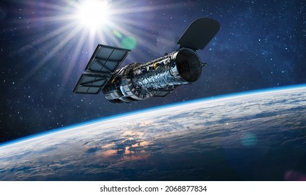 Hubble telescope on orbit of Earth. Space observatory. Telescope in outer space near surface of blue planet. Stars and sun. Elements of this image furnished by NASA