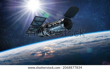 Hubble telescope on orbit of Earth. Space observatory. Telescope in outer space near surface of blue planet. Stars and sun. Elements of this image furnished by NASA