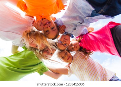 A Huddle Of School Kids Looking Down At Camera,