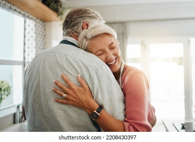 Hug, love and safe with a senior couple hugging or embracing in the kitchen of their home together. Happy, smile and affection with an elderly male and female pensioner sharing a warm embrace - Powered by Shutterstock