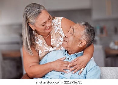 Hug, Love And Senior Couple With Smile For Funny Story While In The Living Room Of Their House. Happy, Comic And Elderly Man And Woman Relax And Hugging For Support In The Lounge Of Their Home