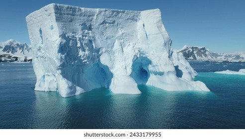 Huge Antarctic iceberg drift blue ocean sunny day. Giant ice glacier at polar nature environment. Global warming. Climate change. Cinematic ecology scene. Antarctica travel and exploration. Panorama - Powered by Shutterstock