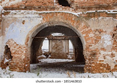 A huge arched doorway in an old abandoned brick building.