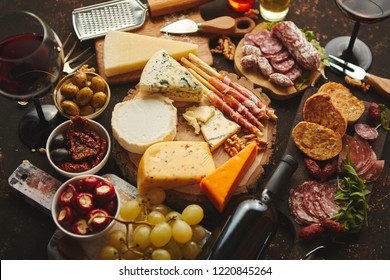 Huge assortment of various tasety spanish, french or italian apertizers. Cheese, meat, olives, stuffed peppers, bread, sticks. Placed on rusty dark background. View from above.