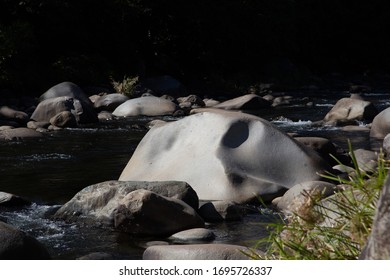 Huge Boulder On The River With Unique Shadows