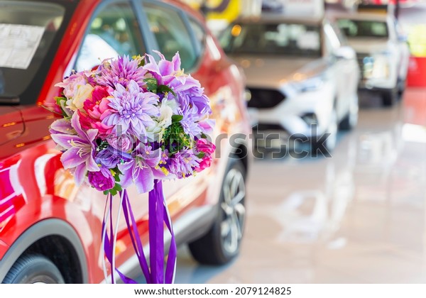 A\
huge bouquet to congratulate for new car ownership. New car at\
dealer showroom floor, showroom for sale at car dealer\
