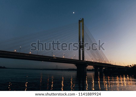 A huge bridge in the background of the sunset, which divides the city into two parts.