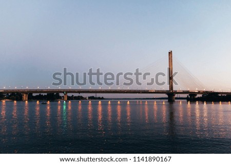 A huge bridge in the background of the sunset, which divides the city into two parts.
