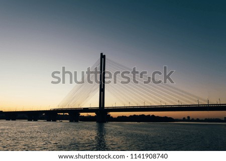 A huge bridge in the background of the sunset, which divides the city into two parts.