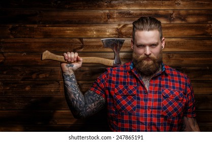 Huge Brutal Man With Beard And Tattooes Holding Axe