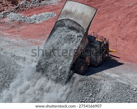 Huge CAEX mining truck in the process of dumping rock material at mine waste dump