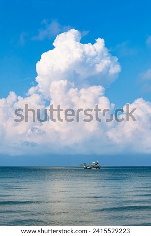 huge clouds above the horizon. White cumulus clouds in sky over blue sea. 