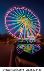 huge colorful ferriswheel rotating in a blue summer night