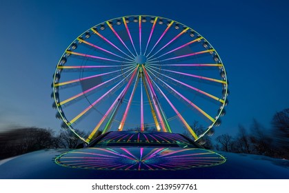  huge colorful ferriswheel rotating in a blue summer night