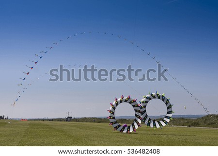 Similar – a colorful garland blows in the wind on the north sea