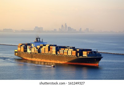 Huge Container Cargo Ship Outgoing From Port At Sunrise 