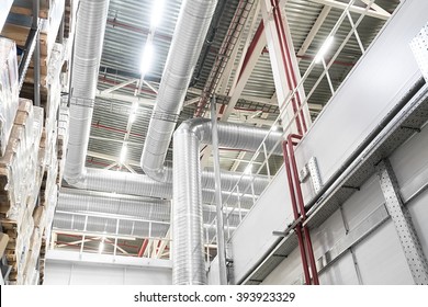 Huge Distribution Warehouse With High Shelves And Big Ventilation Pipes On The Ceiling. Bottom View.