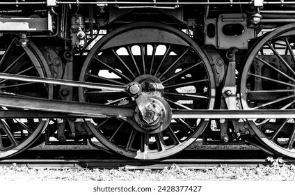 Huge driving wheels of an ancient german steam express train locomotive with cast iron and steel components as symbol for technological inventions and machinery of the past. Black and white vintage. - Powered by Shutterstock