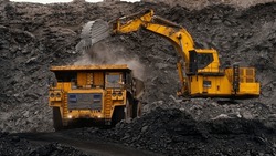 A Huge Excavator Loads Rock Formation Into The Back Of A Heavy Mining Dump Truck. Open Pit Coal Mining.