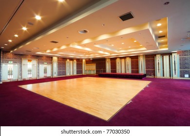 Huge Hall Interior With Wooden Dance Floor,  Red Carpet And Ceiling With Lights In Hotel