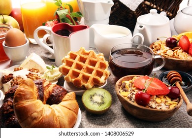 Huge healthy breakfast on table with coffee, orange juice, fruits, waffles and croissants. Cereals and balanced died. Good morning concept.