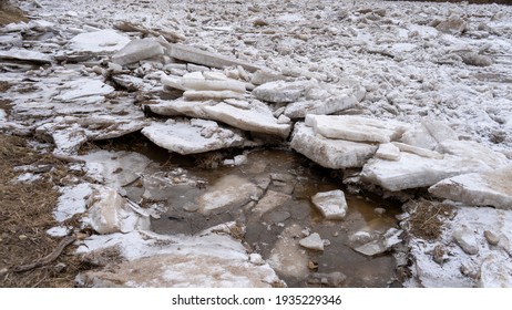 Huge Ice Loads Drift In The River Ogre, Latvia. Congestion On The River In The Spring. A Large Cluster Of Moving Ice Blocks