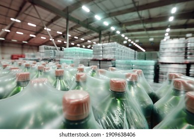 A Huge Industrial Warehouse With Plastic Food Wrap Wrapped Plastic Bottles With Carbonated Drinks, Water Or Beer.