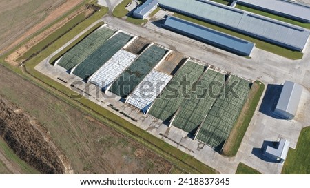 Huge large boxes for outdoor storage of silage, feed for cattle on a large farm. Open-air silage covered with a protective tent. How animal feed is stored on farms.