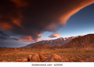 Huge lenticular cloud painted by the setting sun over the Sierra Nevada mountain range with Alabama Hills in the foreground, California - Powered by Shutterstock