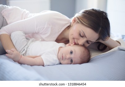 Huge love in the world. Mother and baby on bed. Copy space.