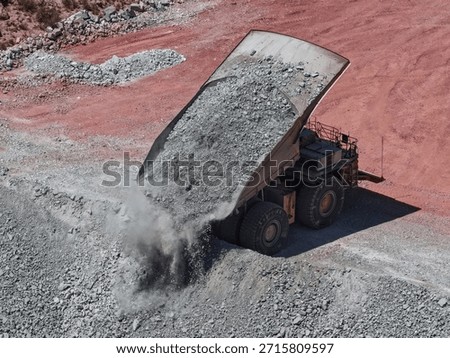 huge mining truck in the process of dumping waste material in mine dumps