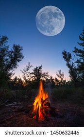 Huge Moon On The Night Sky Above The Camp Fire