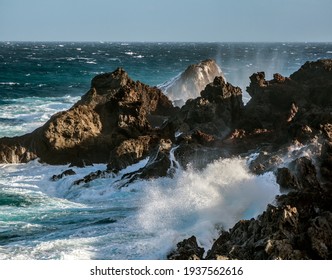 huge ocean waves crashing on the rocks in sunset