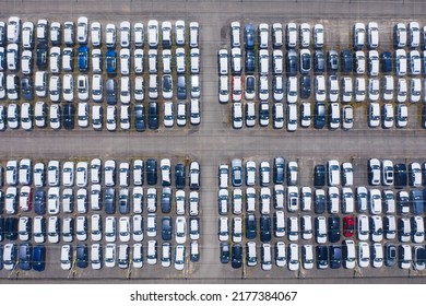 Huge Parking Lot Near Big City. Overhead View Of Big Car Parking.
Aerial View Of New Cars Parked At The Parking Area Of Automobile Factory. Aerial View Above Multicolored Cars On Warehouse Parking Lot