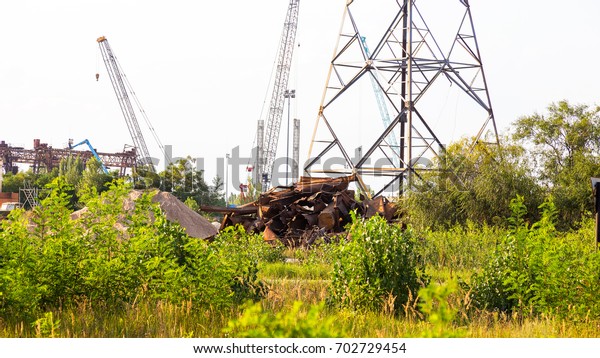 Huge pile of\
scrap metal junk garbage with blue sky background. Scrap metal on\
recycling plant site.\
Chernobyl
