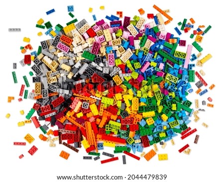 huge pile of stackable plastic toy bricks in top view isolated white background.  Colorful texture childhood education and development concept.