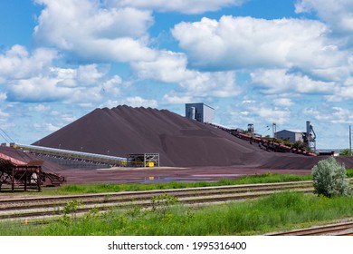 A huge pile of Taconite and assorted equipment located at the Cleveland Bulk Terminal in the harbor at Cleveland, Ohio on Lake Erie