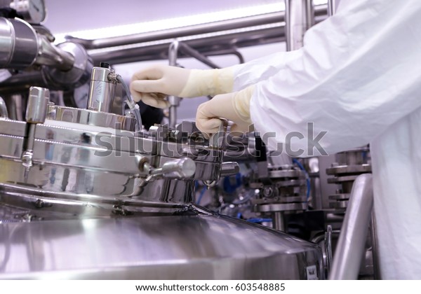A huge rector for the production of medicine.\
The man closes the reactor cover. Preparation of the extract of the\
suspension. Reactor of the pharmaceutical plant. The industry of\
medical medicines.