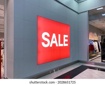 A Huge Red Poster With The Inscription - Sale. On The Gray Wall. There Are Big Discounts In The Store. No People
