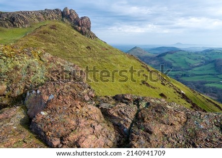 Huge rocks overlooking Shropshire countryside at sunrise,rocky landscape and grass covered hillsides,dramatic scenery from the windy hilltop.