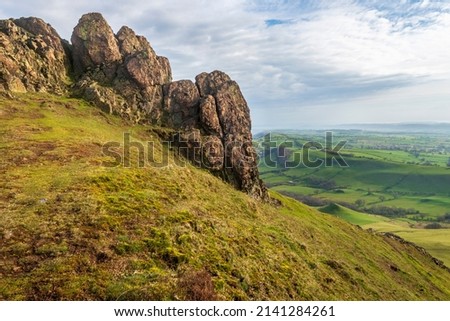Huge rocks overlooking Shropshire countryside at sunrise,rocky landscape and grass covered hillsides,dramatic scenery from the windy hilltop.