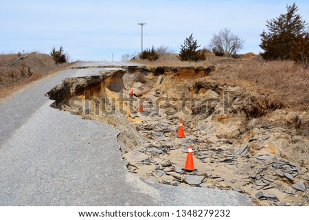 A huge section of a road is eroded by water and destroyed.