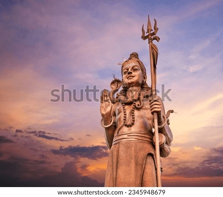 The huge Shiva statue Mangal Mahadev is a 33 m art piece in Ganga talao temple on the blue evening sunset sky, Mauritius island.