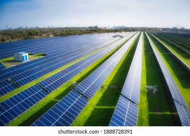 Huge solar power plant to use solar energy in a picturesque green field in Ukraine. Aerial panoramic drone shot