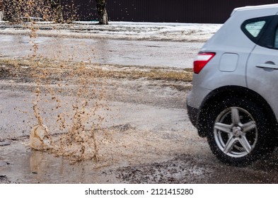 Huge Splash Of Dirty Water Out Of Puddle On Broken Road From A Passing Car In Blurred Motion. Ukraine, Zhytomyr, February 9, 2022